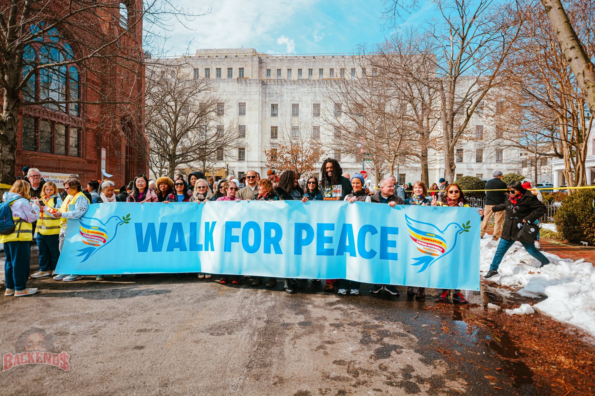 Supporters gathered behind a Walk for Peace banner